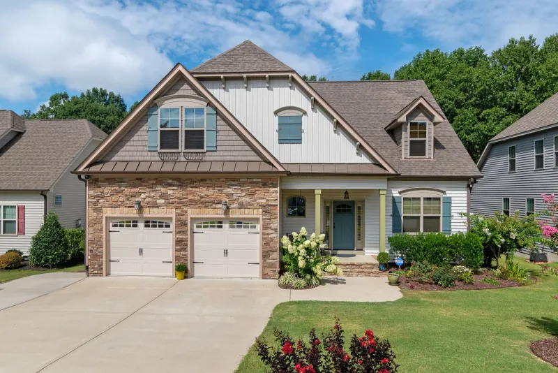 Illustrative stock photo: suburban house with a double garage and landscaped yard