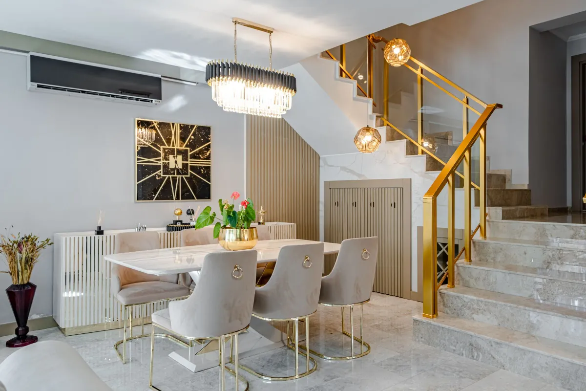 Illustrative stock photo: contemporary dining space beside a staircase with gold railings