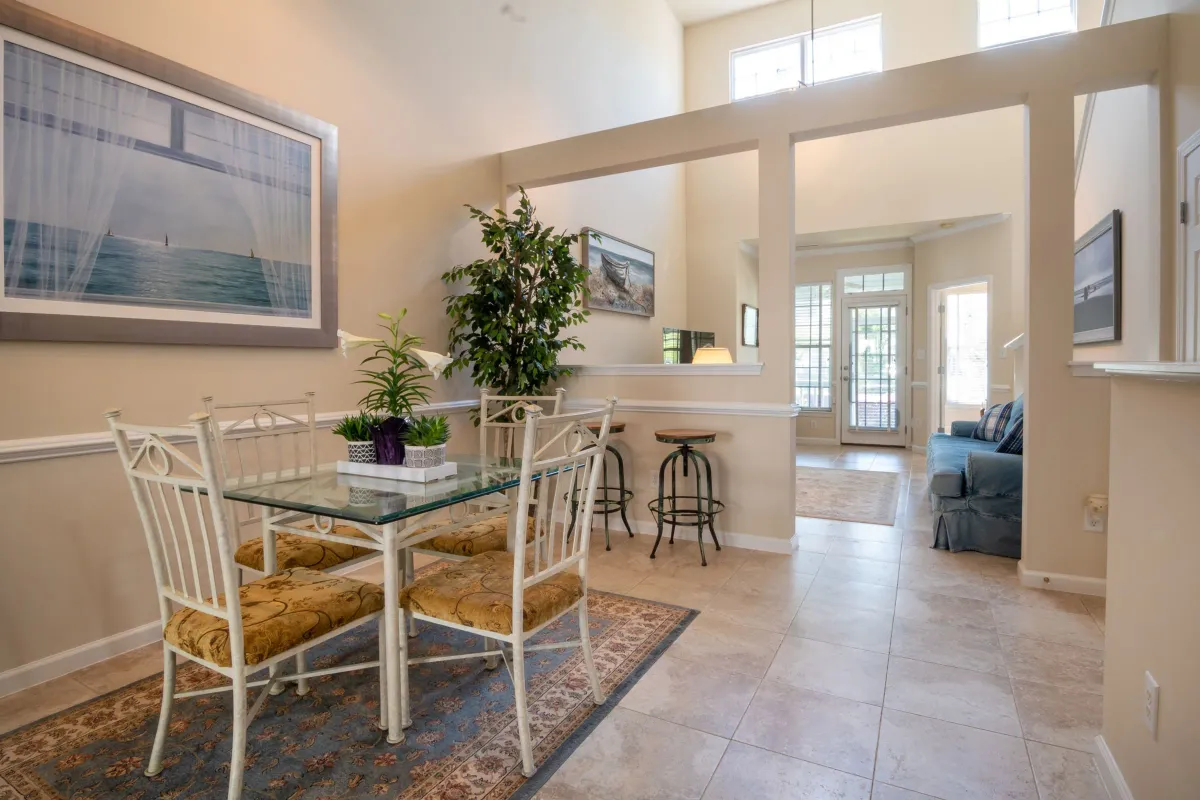 Illustrative stock photo: open dining and living areas with tall windows and natural light