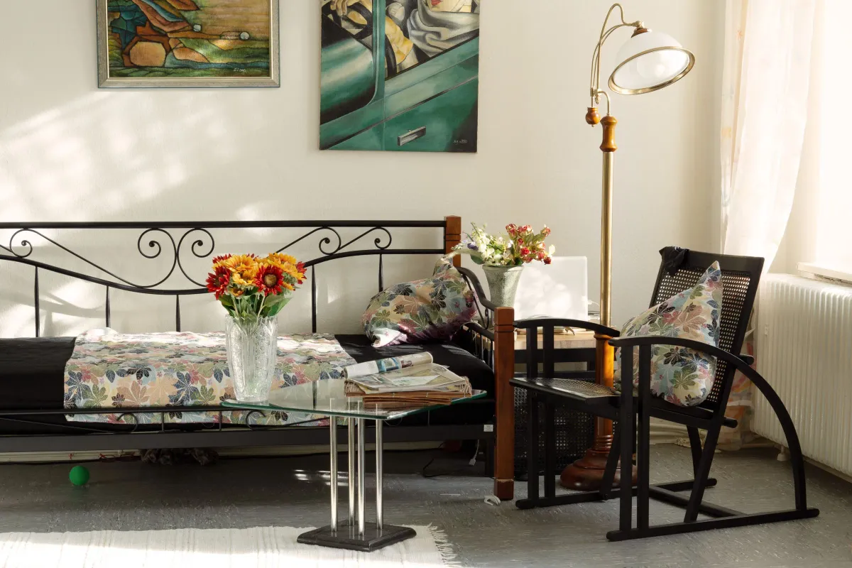 Illustrative stock photo: furnished sitting area with patterned cushions, art and flowers