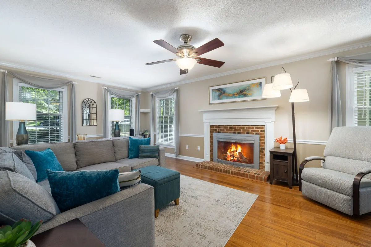 Illustrative stock photo: living room with a blue sofa, fireplace and broad windows