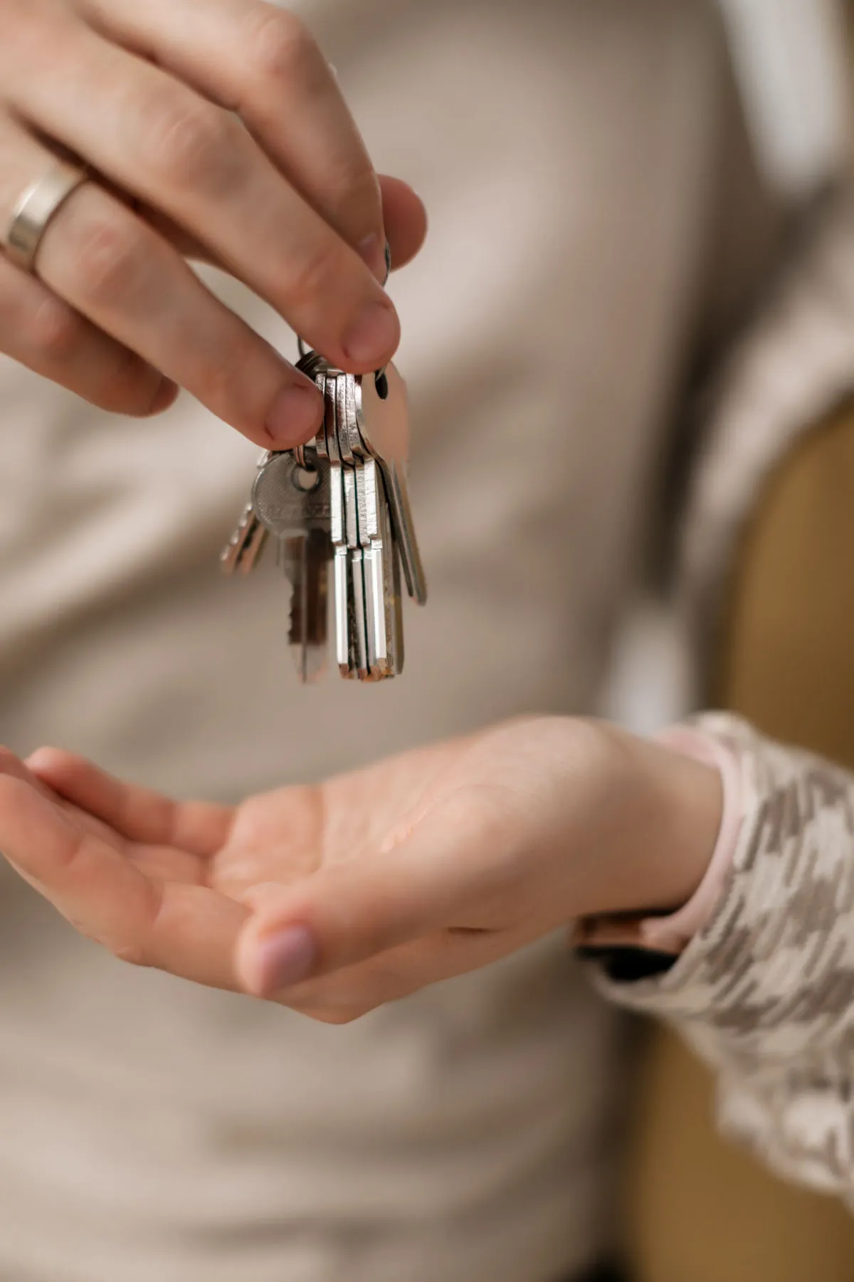 Illustrative stock photo: one person passing a set of house keys to another