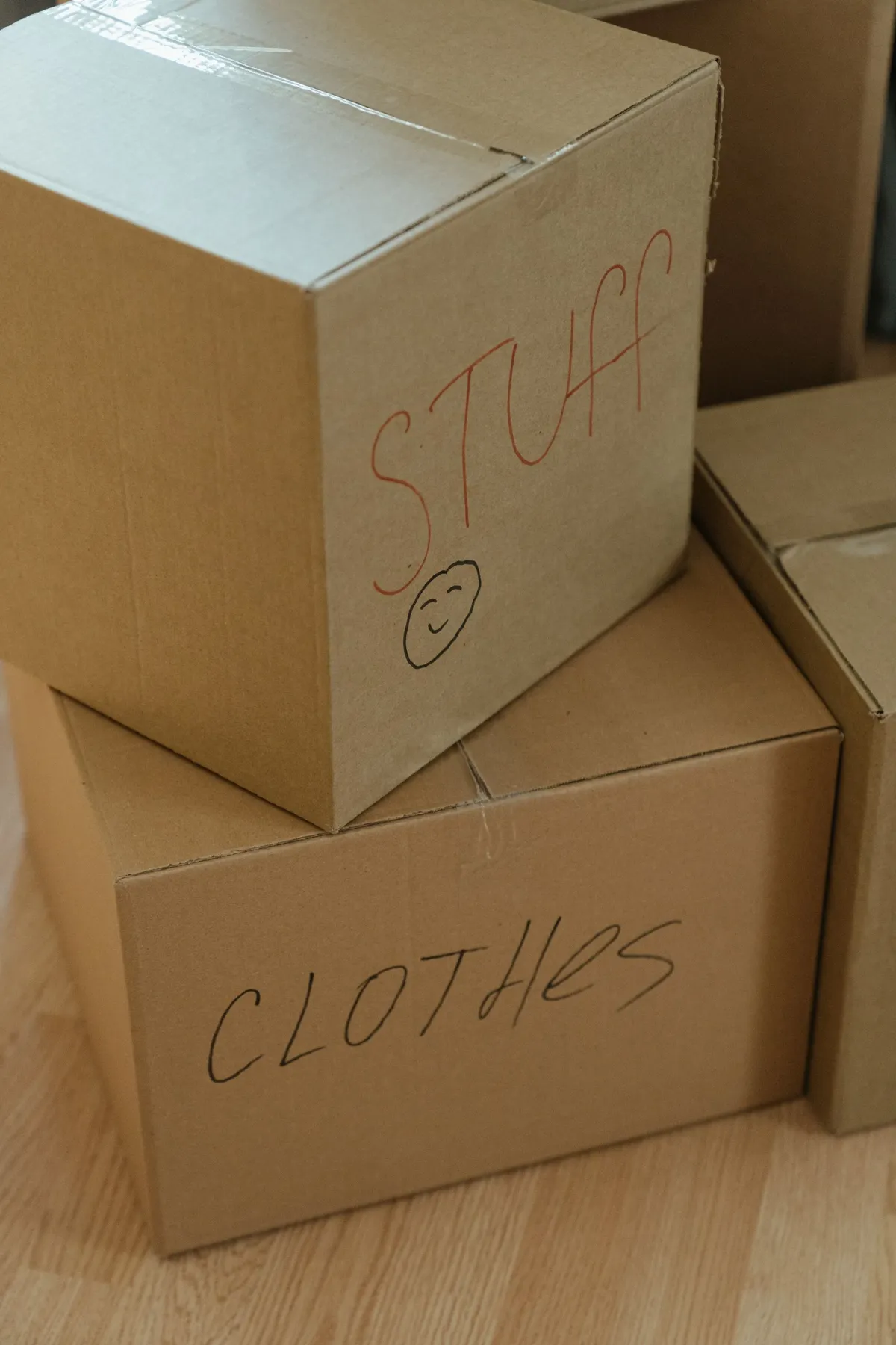Illustrative stock photo: stacked cardboard moving boxes labeled for household belongings