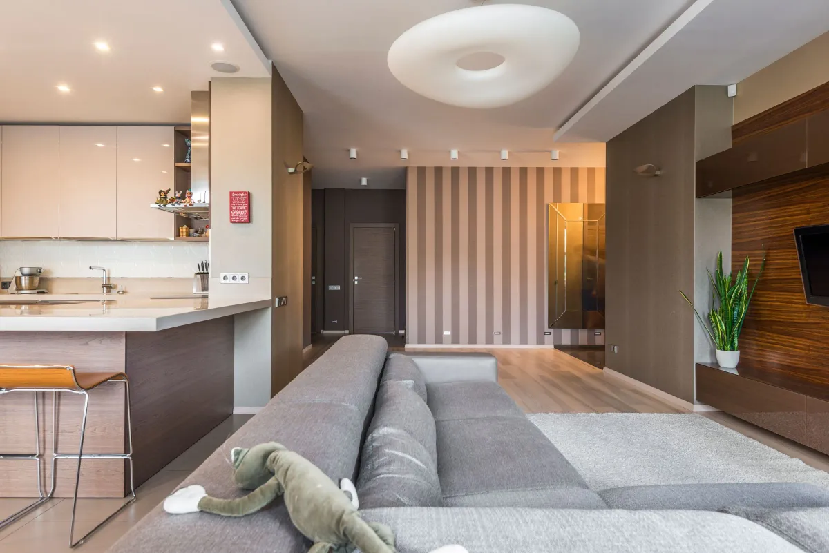 Illustrative stock photo: contemporary open-plan living area with a sectional sofa and kitchen