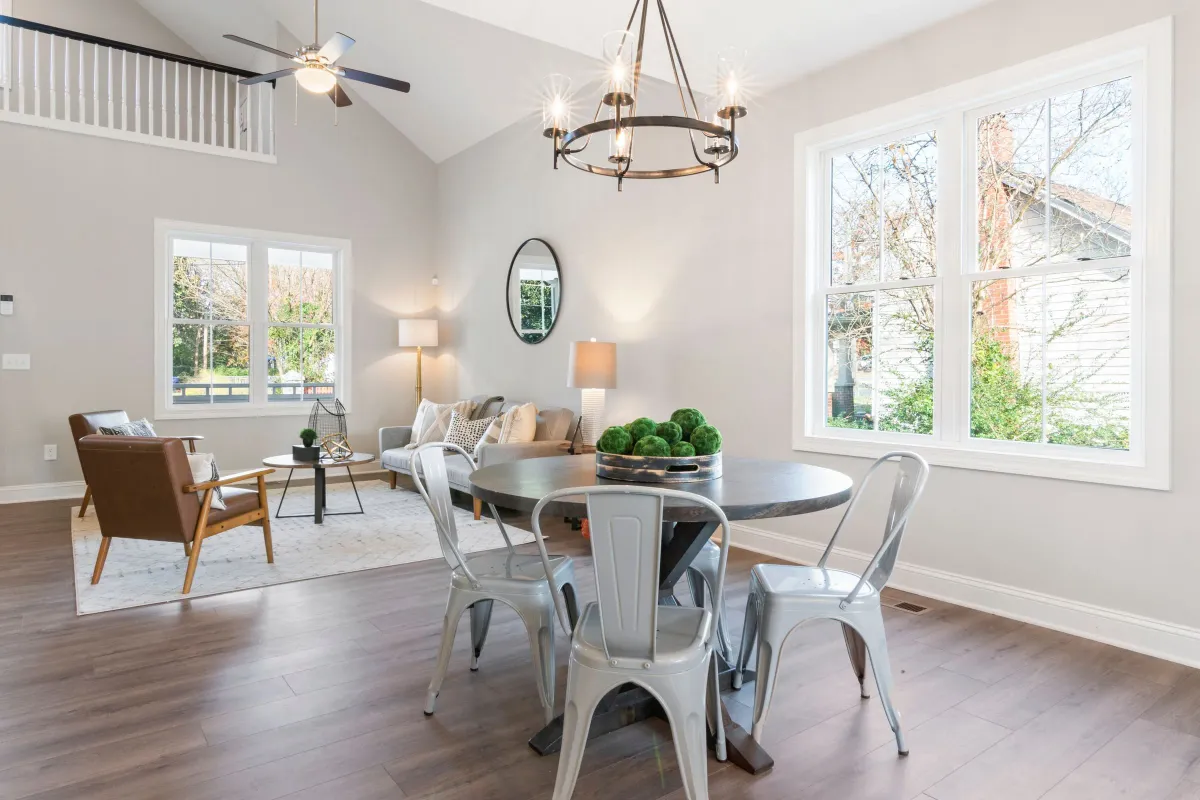 Illustrative stock photo: sunlit dining area with upholstered chairs and a chandelier