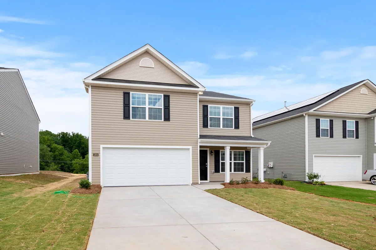 Illustrative stock photo: two-story suburban home with a driveway and front lawn
