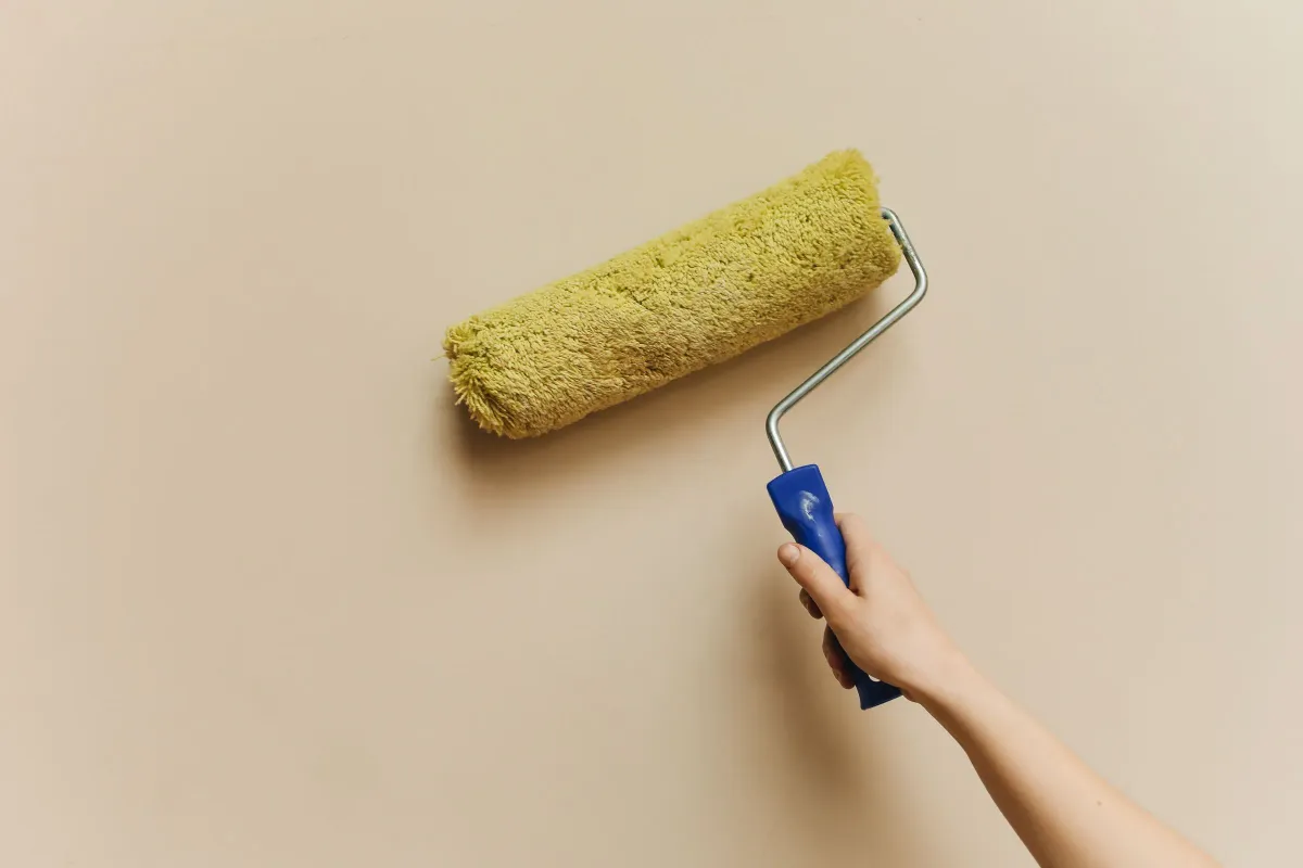 Illustrative stock photo: hand using a paint roller to refresh an interior wall