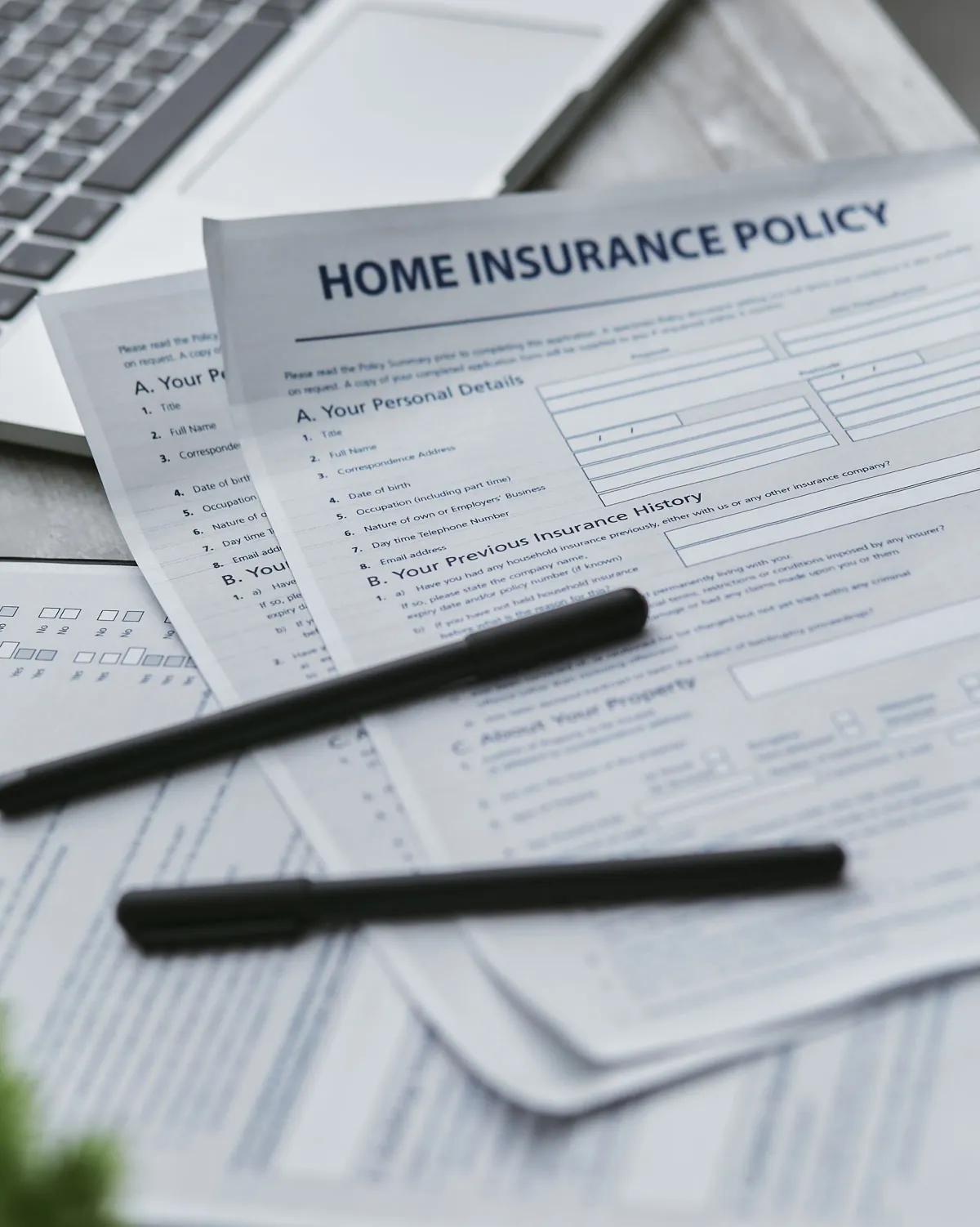 Illustrative stock photo: home insurance paperwork and pens laid out for review