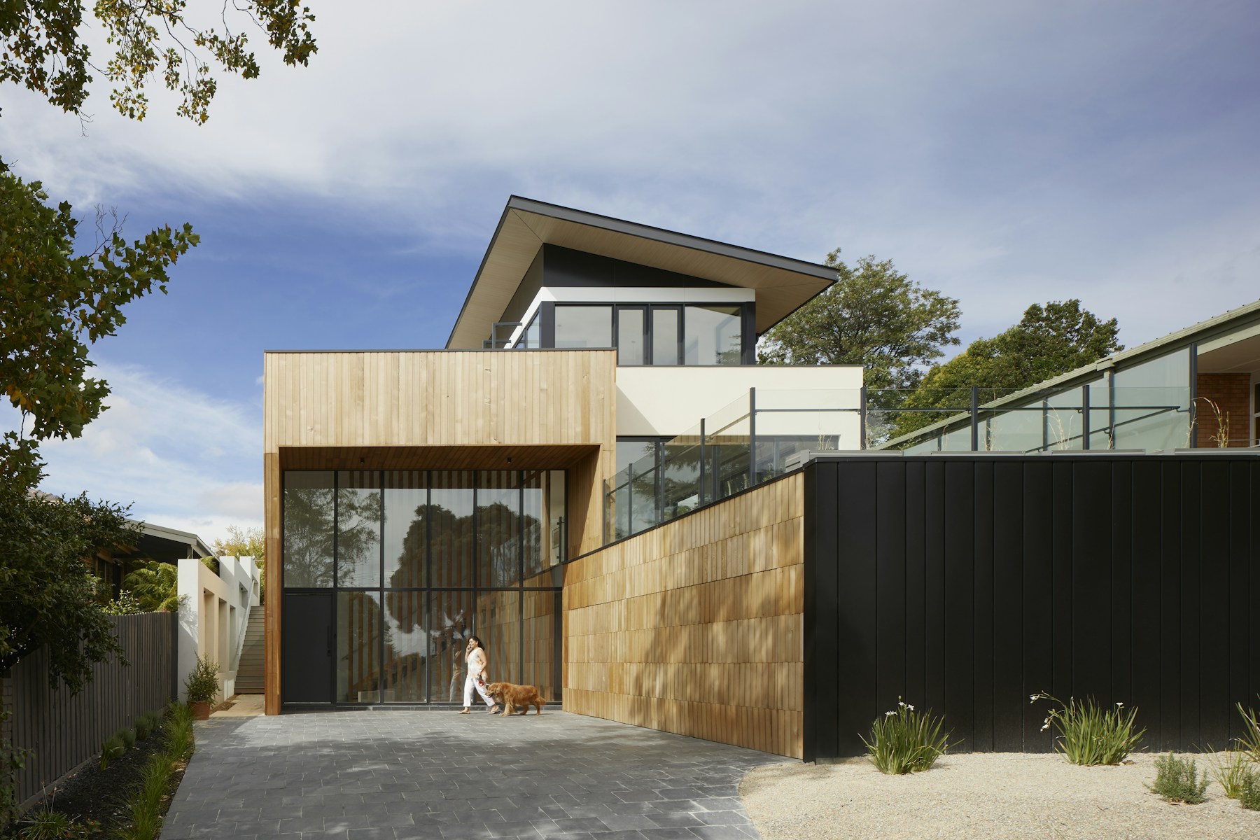 Illustrative contemporary home exterior with timber cladding and angular rooflines
